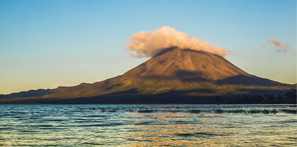 Una montagna che si erge sopra uno specchio d'acqua.