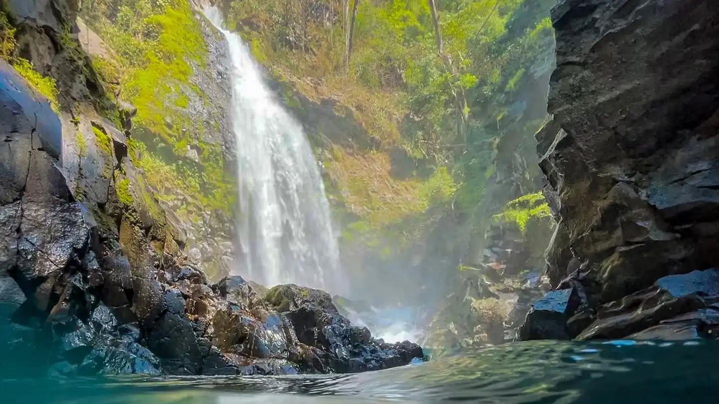 Una cascata al centro di uno specchio d'acqua.