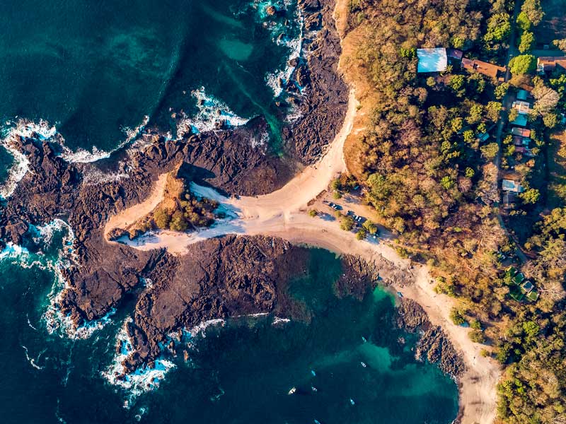 Vista aerea di una spiaggia sabbiosa e dell'oceano.