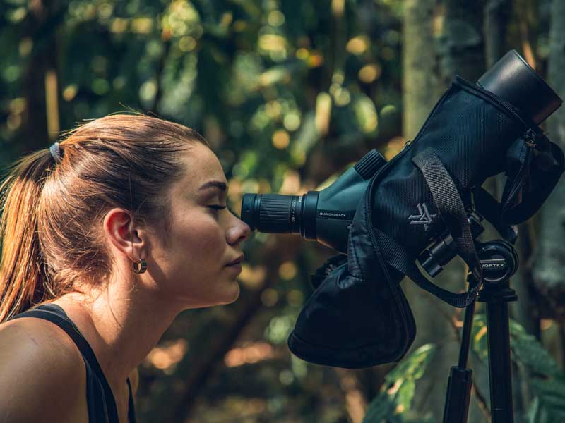 Una donna che guarda attraverso un binocolo.