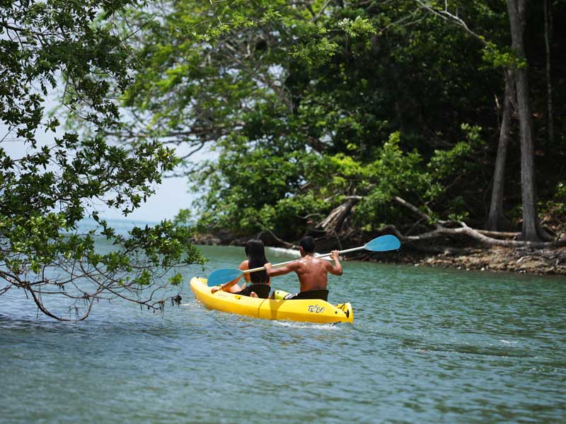 Un uomo sta remando con un kayak nell'acqua.