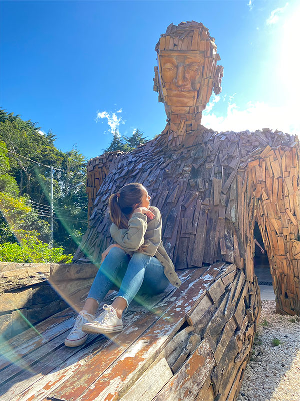 Una donna seduta su una panchina di legno.