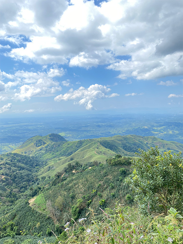 Una vista panoramica di una catena montuosa con nuvole nel cielo.