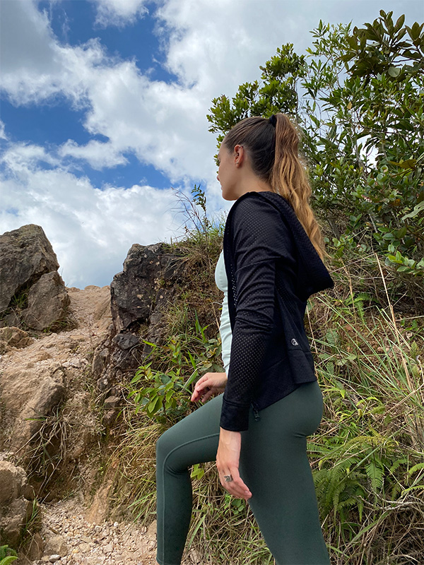 Una donna in top nero e leggings verdi