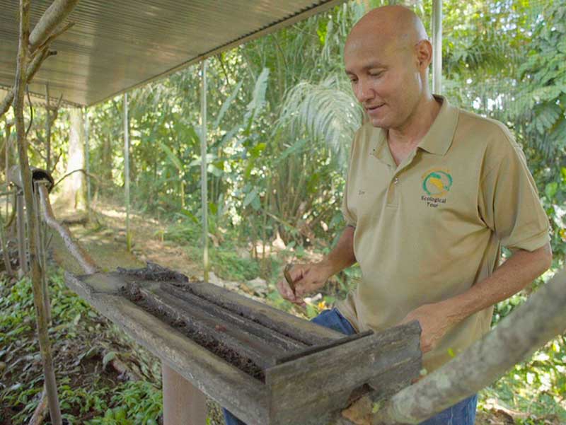 Un uomo in piedi accanto a una scatola di legno.