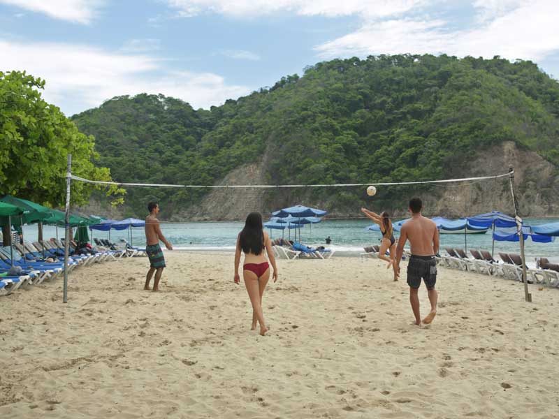 Un gruppo di persone che gioca a pallavolo su una spiaggia.