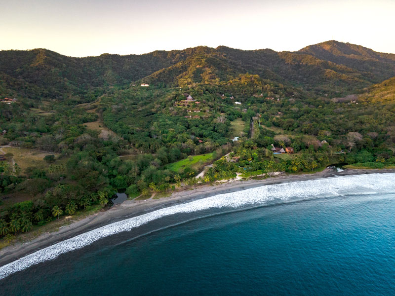 Una vista a volo d'uccello su una spiaggia e sulle montagne.