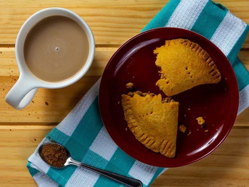 Due pezzi di torta su un piatto accanto a una tazza di caffè 