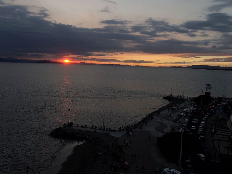 Un grande specchio d'acqua con un tramonto sullo sfondo.