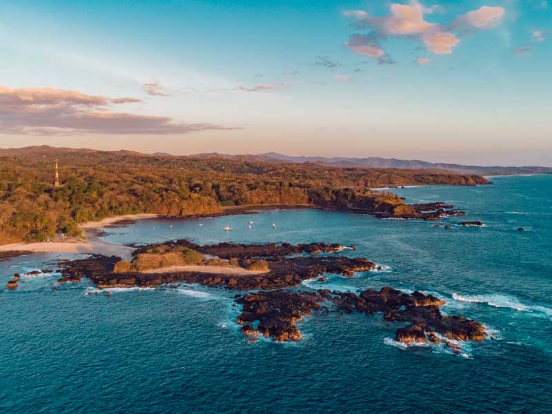 Vista aerea di un'isola tropicale con spiaggia sabbiosa.