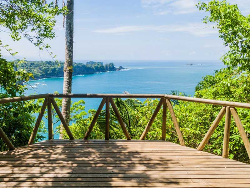 Una terrazza in legno con vista sull'oceano.