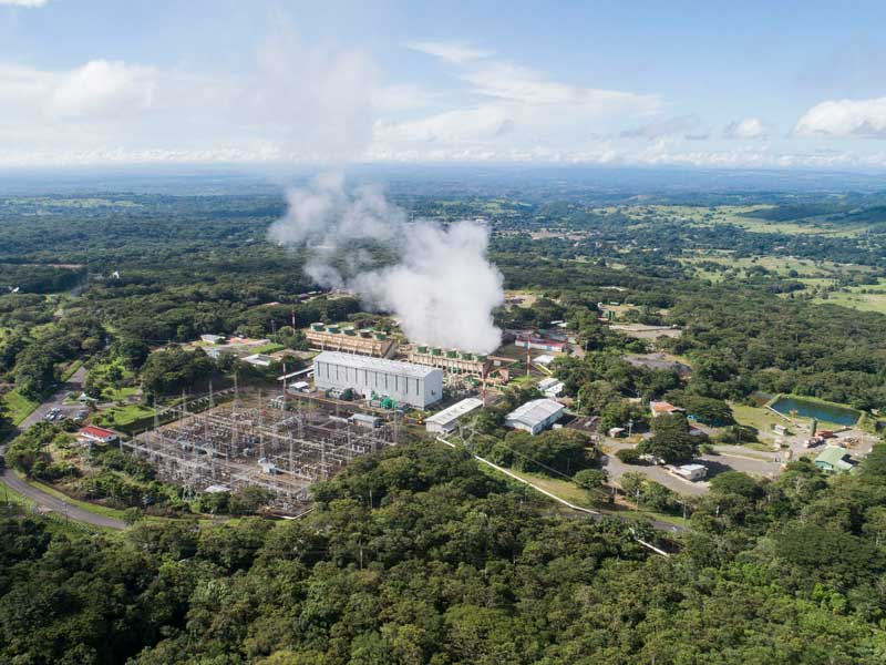 Veduta aerea di una fabbrica da cui esce del fumo.