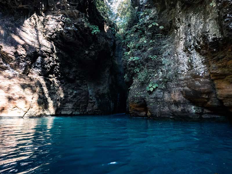 Uno specchio d'acqua circondato da una scogliera rocciosa.