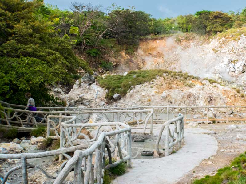 Un uomo che attraversa un ponte di legno su un fiume.