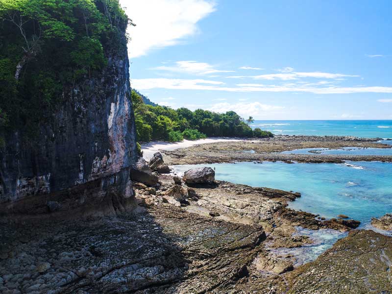Una vista di una spiaggia rocciosa con acqua limpida e azzurra