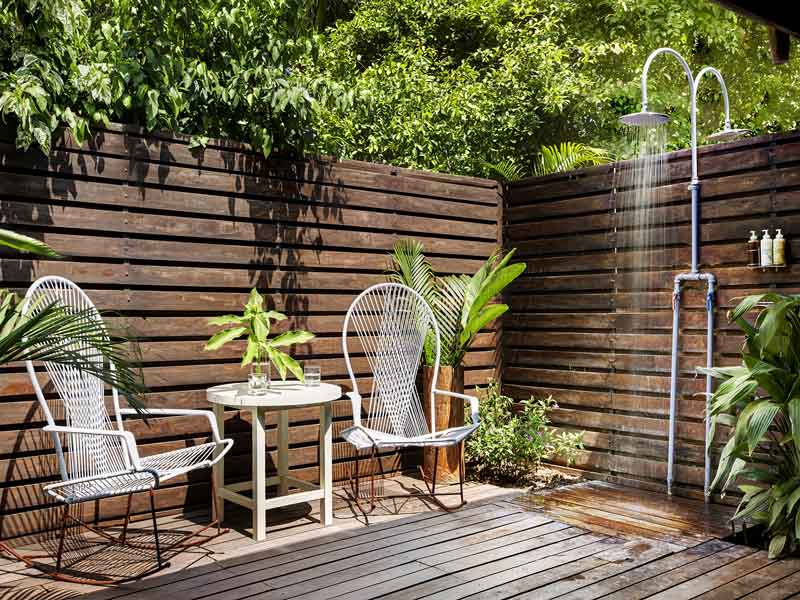 Una terrazza in legno con due sedie e un tavolo.