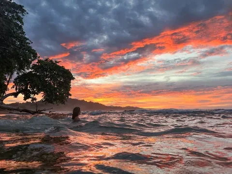 una persona nell'oceano al tramonto
