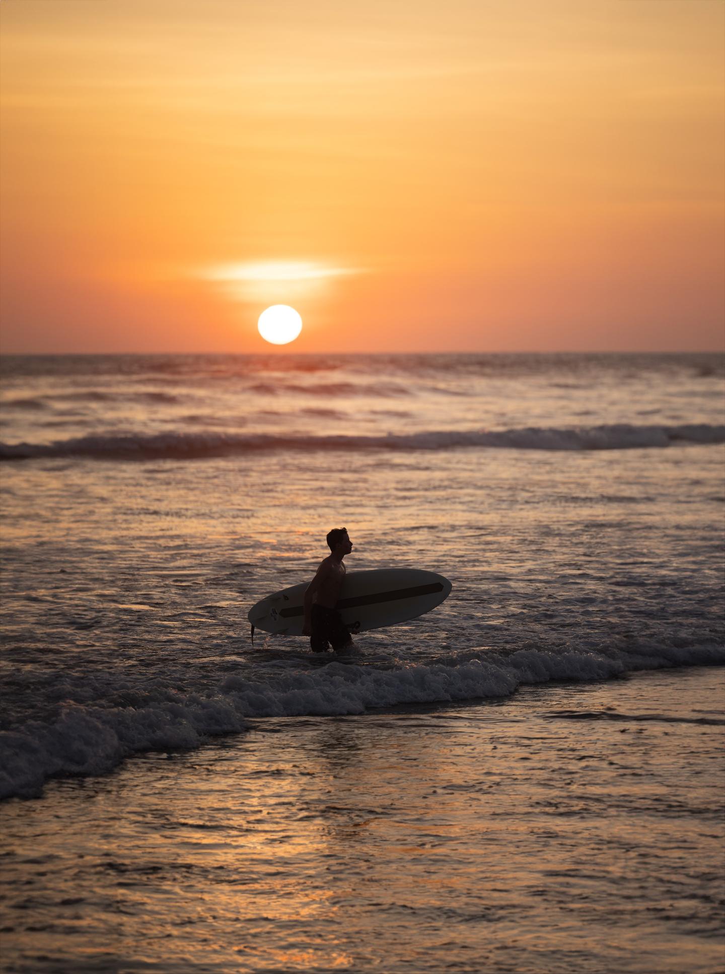 uomo che fa surf all'alba oceano guiones