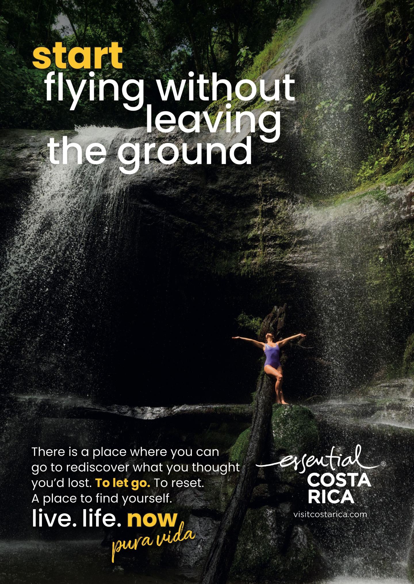 Pubblicità che ritrae una cascata in una rigogliosa foresta pluviale; una persona è in piedi su un tronco davanti alla cascata con le braccia aperte. Titolo: «Inizia a volare senza lasciare terraferma». Marchio: «esencial Costa Rica, visitcostarica.com.